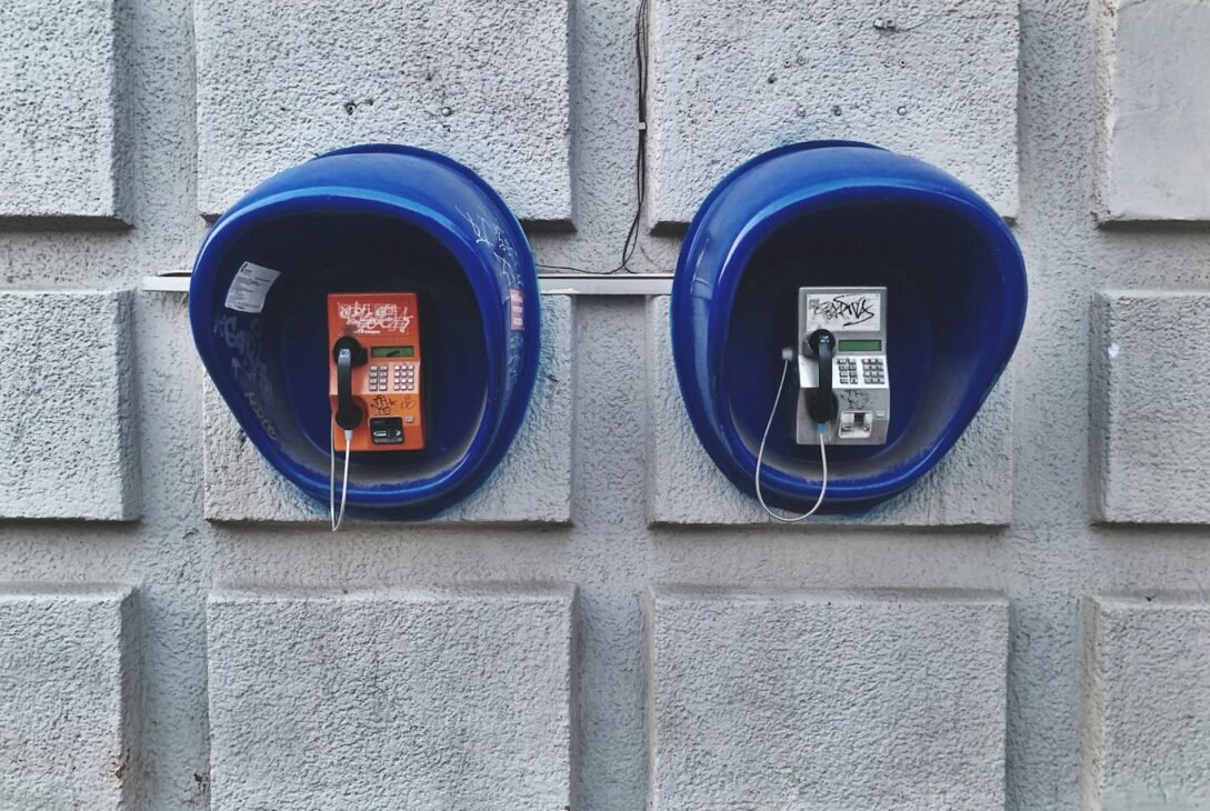 two blue telephone booths on wall