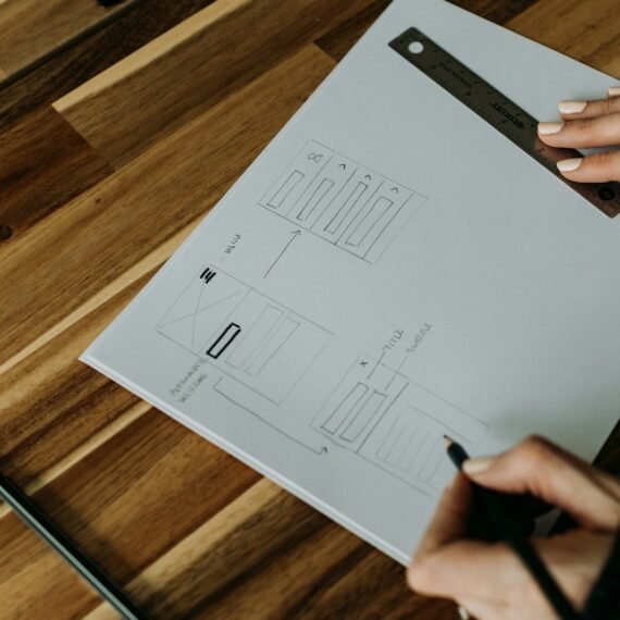 a person holding a pen over a piece of paper