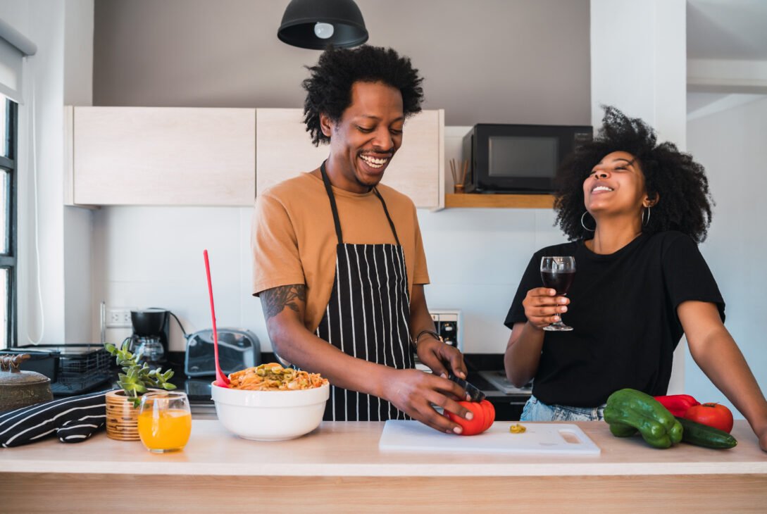 Afro couple cooking together in the kitchen.