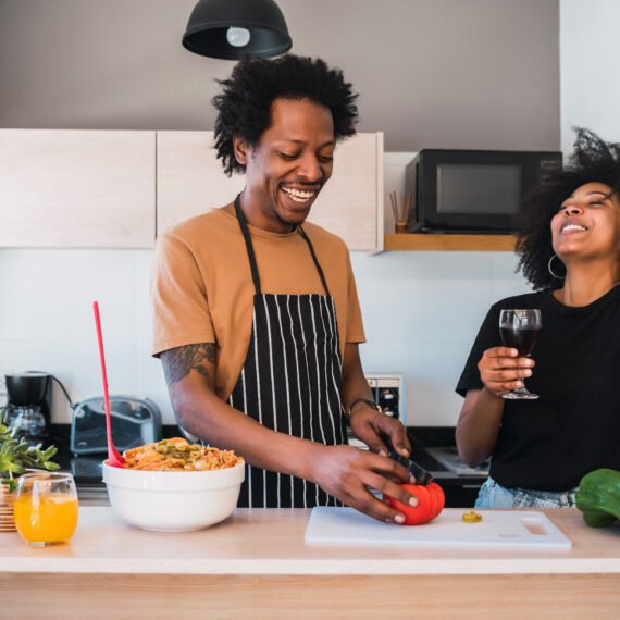 Afro couple cooking together in the kitchen.