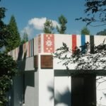 a white building with a red, white, and blue flag on top of it