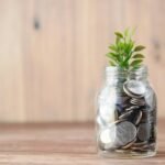 a glass jar filled with coins and a plant