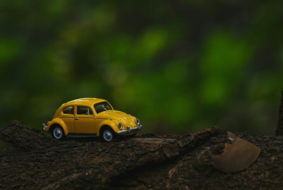 yellow coupe scale model on brown wooden surface