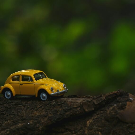 yellow coupe scale model on brown wooden surface