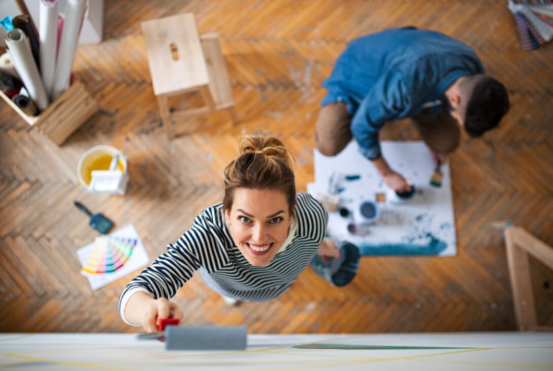 Top view of couple painting wall indoors at home, relocation and diy concept