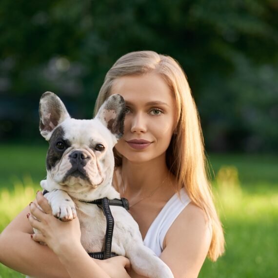 Woman holding french bulldog outdoors