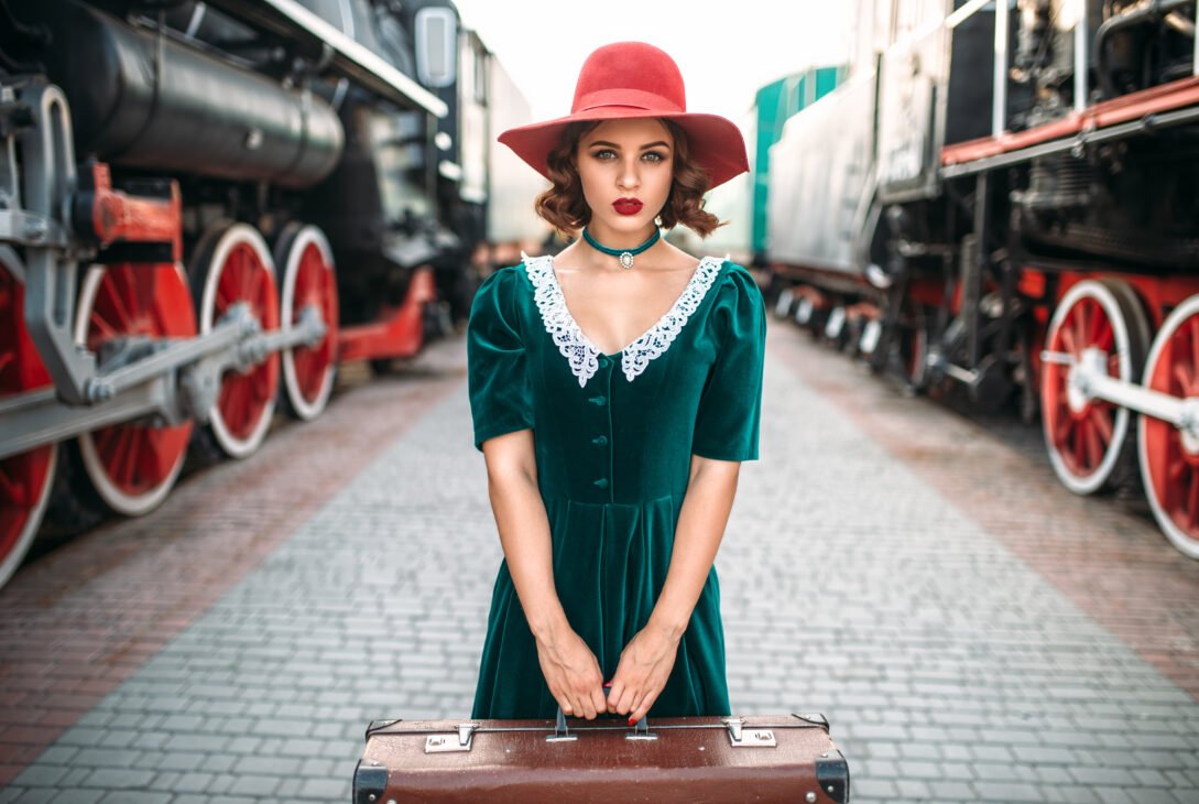 Young old-fashioned woman travels on retro train